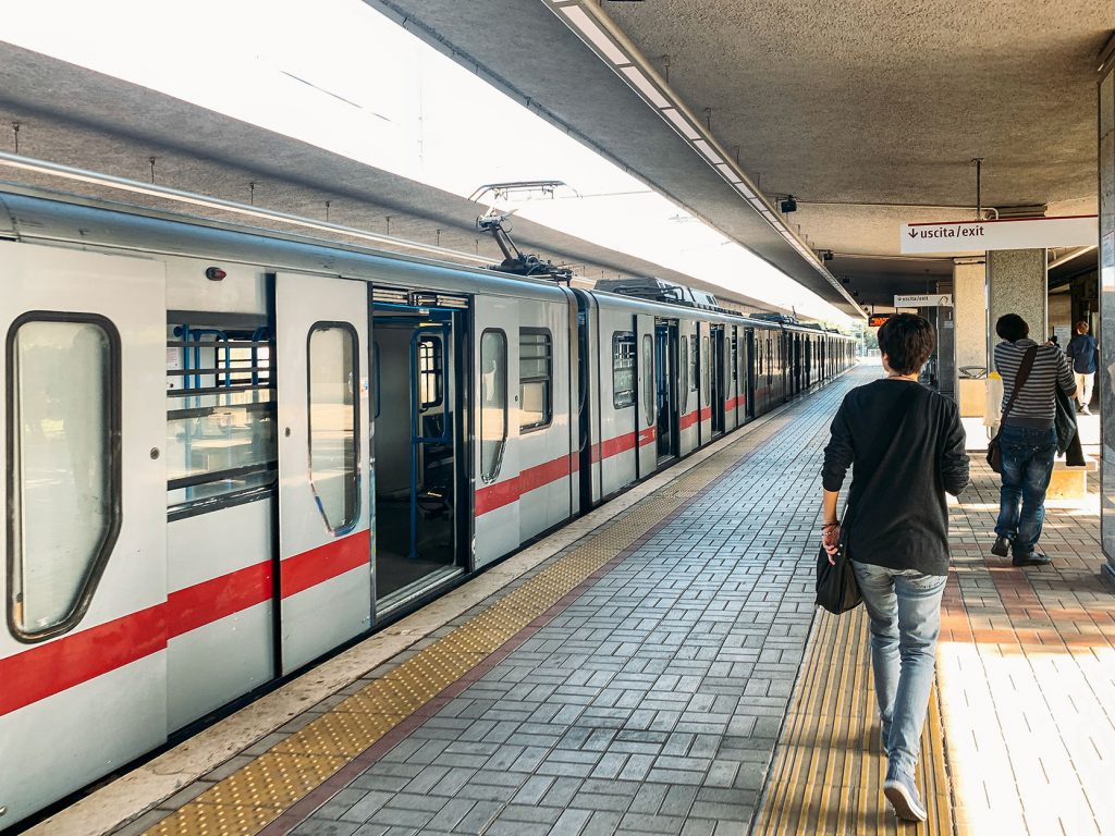 Outdoor railway train station in Italy with passengers, public transport